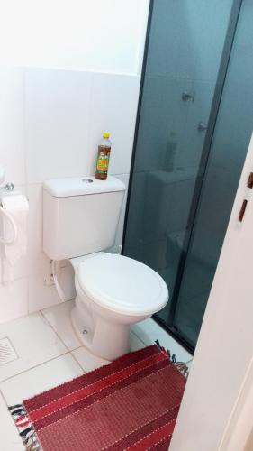 a bathroom with a toilet and a glass shower at Apartamento no val in Valparaíso de Goiás