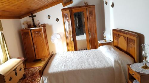 a bedroom with a white bed and a wooden cabinet at Casa da Palmeira in Outeiro da Cortiçada