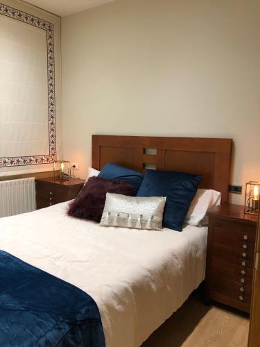 a bedroom with a large bed with blue pillows at O recuncho in Monforte de Lemos