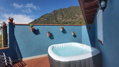 a hot tub on a balcony with a blue wall at Casa Rural La Resbala - Casa Drago in La Orotava