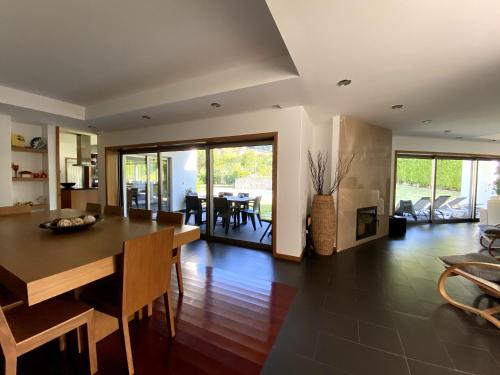 a dining room and living room with a table and chairs at Casa Vale da Cortinha - Near Gerês in Vieira do Minho