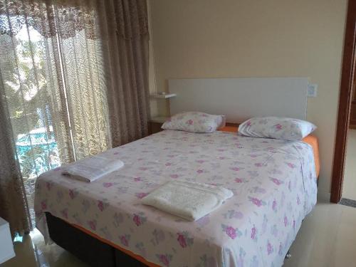 1 dormitorio con 1 cama con 2 toallas en Residence Vila Europa, en Porto Seguro