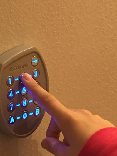 a person pressing a remote control with their hand at Casa Martimbola Self Check-in in Arezzo