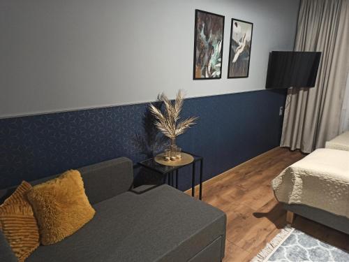 a living room with a couch and a bed at Apartament CCH - Biskupia in Chełmno