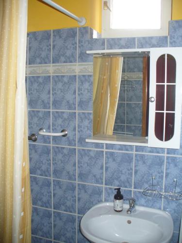 y baño con lavabo y espejo. en Pleiveisz Apartman, en Sárvár