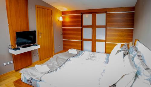 a bedroom with a large bed and a television at Luxury houses in Dobrinishte in Dobrinishte