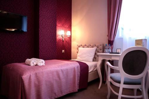 a hotel room with two beds and a table and a chair at Hotel Madelaine in Lwówek Śląski