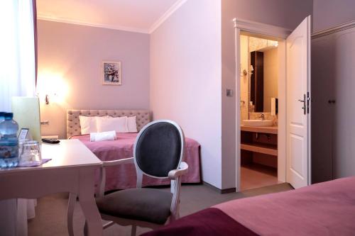 a bedroom with a desk and a bed with a sink at Hotel Madelaine in Lwówek Śląski