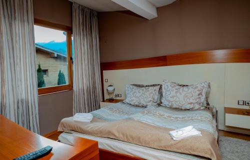 een slaapkamer met een bed, een bureau en een raam bij Luxury houses in Dobrinishte in Dobrinishte