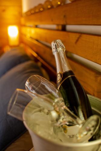 a bottle of champagne in a bucket at Pousada Cabanas Kaia Lua in Praia do Rosa