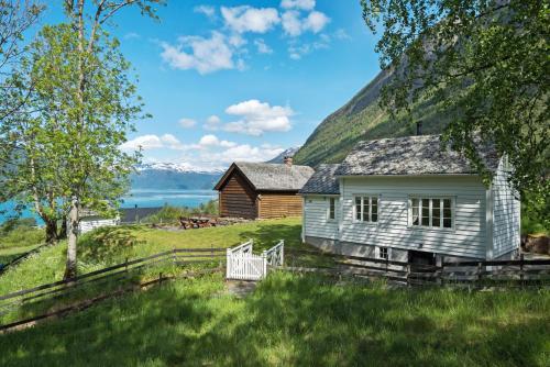 an old house with a mountain in the background at Huse Gjestegard in Kinsarvik