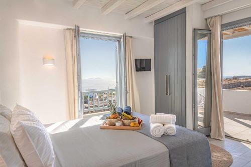 a bedroom with a bed with towels and a window at Villa Iakinthos by Mykonian Kazarte in Mýkonos City