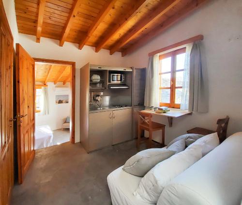 a living room with a white couch and a kitchen at St. George Studios in Rhodes Town