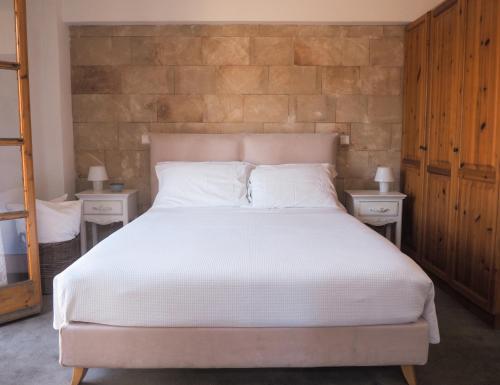 a bedroom with a large white bed with two night stands at St. George Studios in Rhodes Town