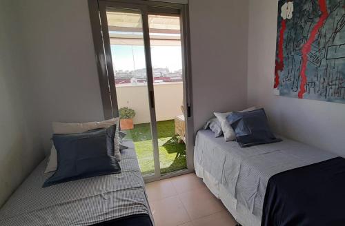 una camera con due letti e una finestra di Ático con vistas a la ría de Punta Umbría a Punta Umbría