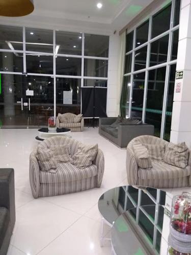 a living room with couches and tables in a building at Flat Clarissinha in Itacuruçá