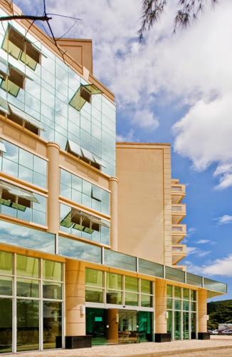 a large building with glass windows on the side of it at Flat Clarissinha in Itacuruçá