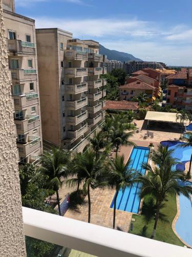 a view of the pool from the balcony of a hotel at Flat Clarissinha in Itacuruçá