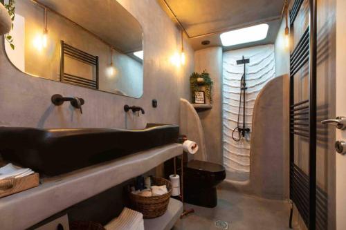 La salle de bains est pourvue d'une baignoire noire et d'un lavabo. dans l'établissement View and the city, à Thessalonique