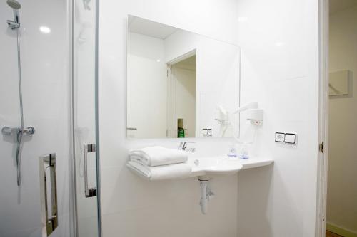 a white bathroom with a sink and a mirror at Morlans Garden in Paguera