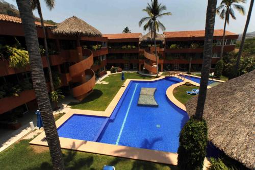 an aerial view of a hotel with a swimming pool and palm trees at La Ceiba del Mar in Zihuatanejo