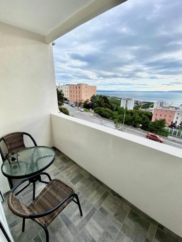 balcón con mesa de cristal, sillas y vistas. en Apartment Lilly, en Rijeka
