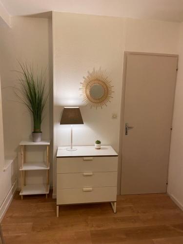 Cette chambre comprend une commode avec une lampe et un miroir. dans l'établissement chez Muriel,T2 de charme, parc Ste Marie, Nancy Thermal, Mon Désert, à Nancy