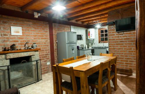 a kitchen with a wooden table and a fireplace at Cabañas Abigail in Nono