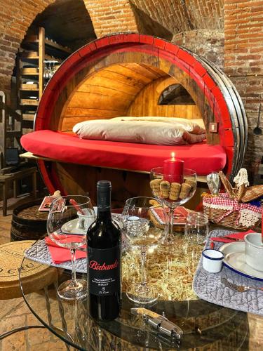 a bottle of wine sitting on a table with wine glasses at Al Silter in Capriate San Gervasio