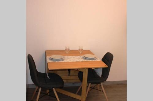 a wooden table with two wine glasses on it at Au pied des Thermes in Amélie-les-Bains-Palalda