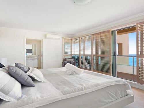a bedroom with a large bed with a view of the ocean at Le Point 702 Luxury and Views in Forster