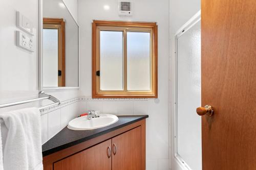 a bathroom with a sink and a mirror at Murray River Holiday Park in Moama