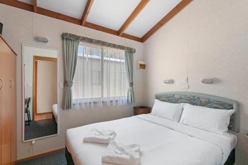 a bedroom with a large white bed with towels on it at BIG4 Moama Holiday Park in Moama