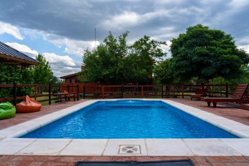 basen w ogrodzie z ławkami wokół niego w obiekcie Cabañas Abigail w mieście Nono