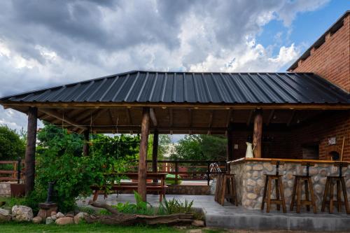 a wooden pavilion with a table and a brick building at Cabañas Abigail in Nono