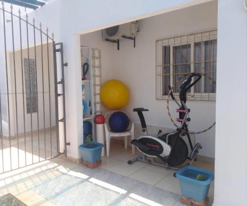 una habitación con un gimnasio con cinta de correr y equipo de ejercicios en DEPARTAMENTO CON PATIO Y PARRILLA, en Encarnación