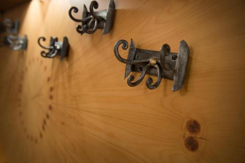 a wooden wall with some metal hooks on it at Hotel Centro's in Livigno