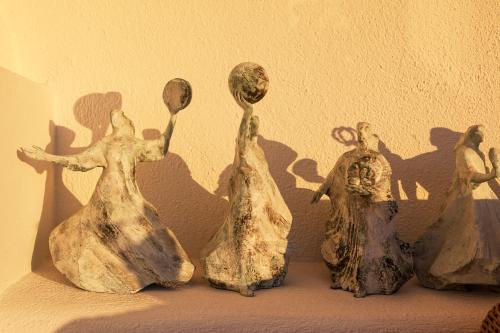 a group of figurines sitting on top of a wall at The Tsitouras Collection in Firostefani