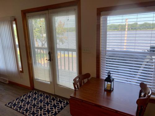 comedor con mesa de madera y 2 ventanas en Mississippi River Cabin, en Bellevue