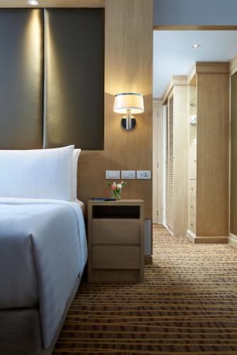 a bedroom with a bed and a table with a lamp at Amari Bangkok in Bangkok