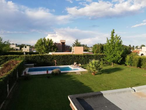 a backyard with a swimming pool and a lawn at Casa con pileta entre bodegas y viñedos - Habitación con baño en suite in Ciudad Lujan de Cuyo