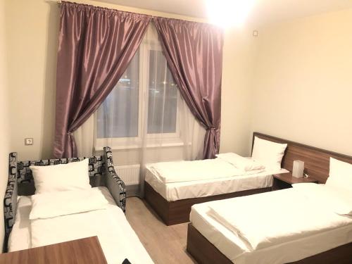 a room with two beds and a window at Отель Лайнер in Khimki