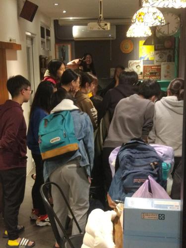 a group of people standing in a room with luggage at mydeer backpacker in Tainan