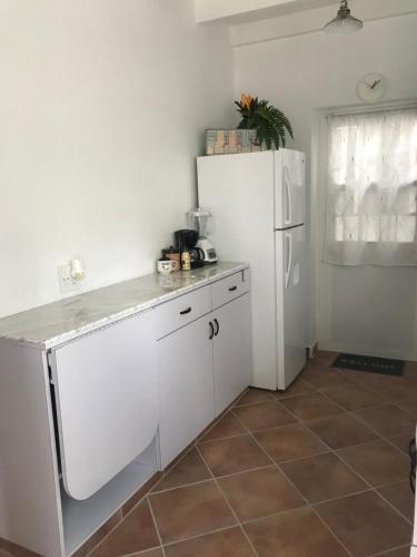 a kitchen with a white refrigerator and a tile floor at Apartment Star 39 in Oranjestad
