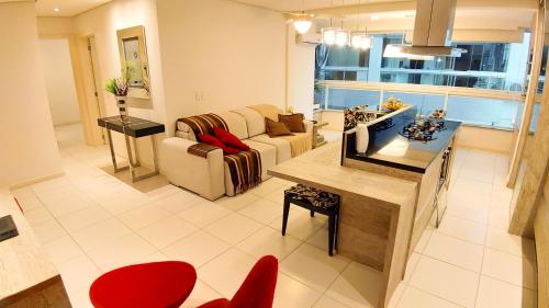 sala de estar con sofá y mesa en Porto Del Mar - 80m da Praia, en Florianópolis