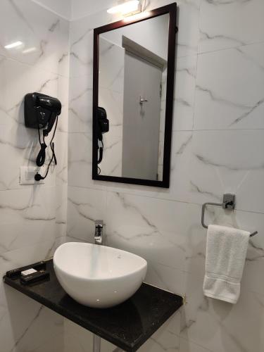 a bathroom with a white sink and a mirror at PARK IRIS HOTELS, Bharathi Nagar in Vijayawāda