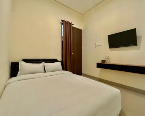 Un pat sau paturi într-o cameră la RedDoorz at Arkana Seturan Pakuwon Mall