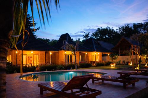 une villa avec une piscine la nuit dans l'établissement Alwi Villa Gili Trawangan, à Gili Trawangan