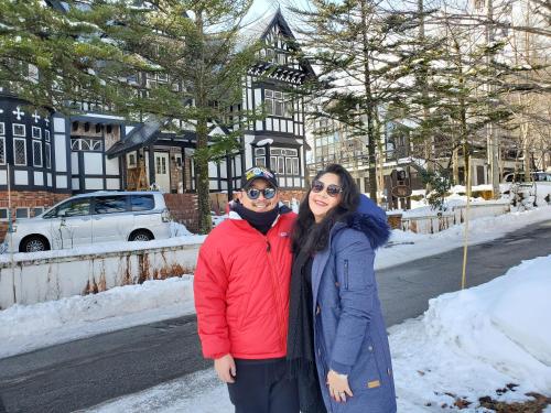 a man and woman posing for a picture in the snow at プチホテル葡萄屋 in Hakuba