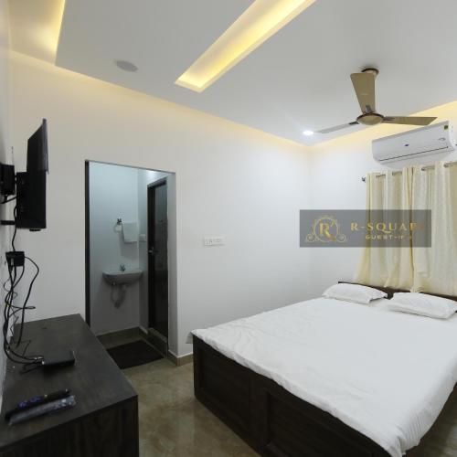 a bedroom with a bed and a tv and a mirror at R Square Guest inn in Nellore